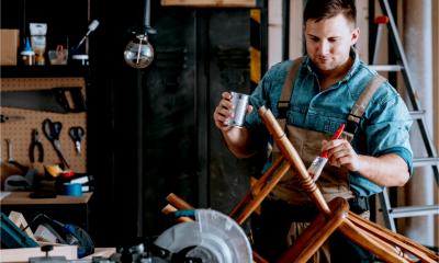 A self-employed carpenter repairs a chair