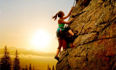 A woman is rock climbing - adventure and extreme sport concept