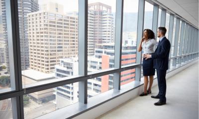 Man and woman viewing an office space by the window