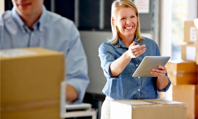 A smiling businesswoman prepares orders for shipping