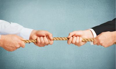 Two businessmen in a tug of war, blue background