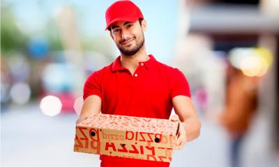 A pizza delivery driver hands over the pizzas