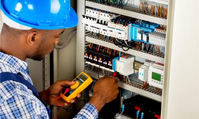A male electrician checks a fuse box