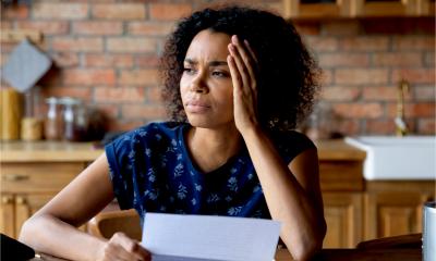 Stressed African-American woman looks frustrated as she doesn't have the money to pay an unexpected expense