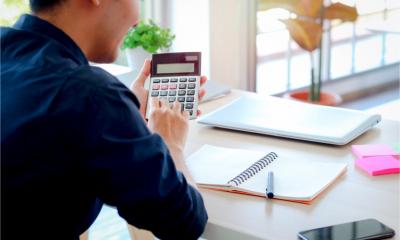 A man works out the VAT he must add to an invoice