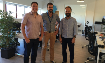 Three employees stood in an office explaining how a tech communications company