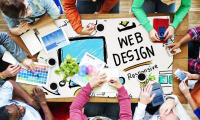 Overhead shot of web developers sitting around a table for a meeting
