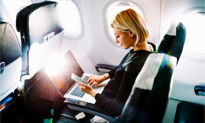Young businesswoman works on her laptop computer during plane flight