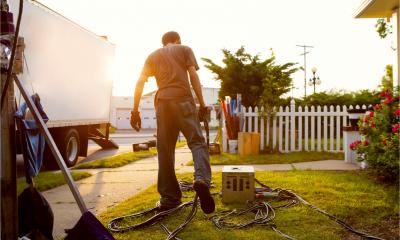 A film crew prepare for a day's shoot in a front garden